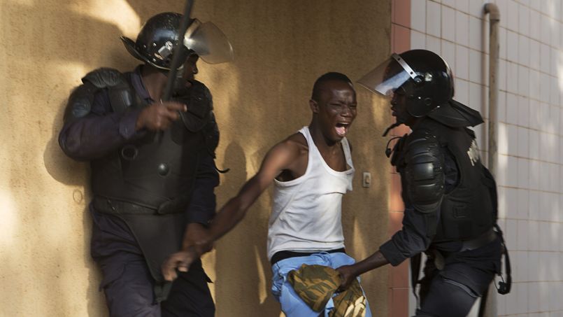 Riot police arrest an anti-government protester in Ouagadougou
